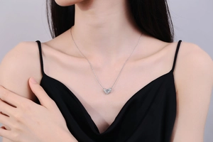 Detail of s925 silver guardian wings necklace with sparkling heart moissanite on model