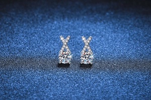 Macro shot of S925 sterling silver X-shape stud earrings with a 0.5ct moissanite drop