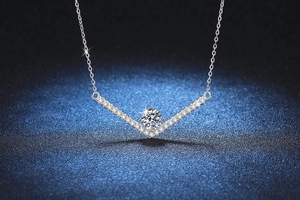 Macro shot of V-shaped sterling silver pendant featuring 1ct Moissanite and pavé diamonds