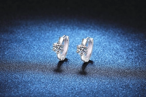 Dettaglio degli orecchini in argento con castone a sei griffe e pietre in moissanite