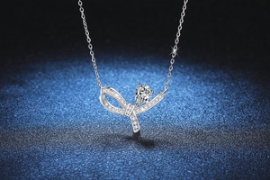 Détail macro du pendentif nœud en argent S925 avec moissanite poire et cristaux pavés