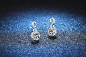 Gros plan sur les boucles d'oreilles infini en argent 925 avec diamants moissanite ronds