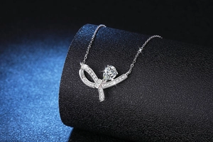 Détail macro du collier en argent S925 avec pendentif nœud et pierre moissanite poire