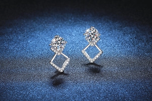 Dettaglio macro di orecchini geometrici in argento con moissanite e incastonatura micro-pave