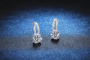 Macro detail of 925 silver moissanite earrings with interwoven micro-pave diamond design