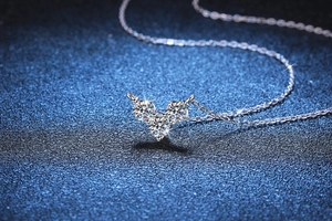 Vue macro d'un collier en argent S925 avec trois pierres de moissanite rondes