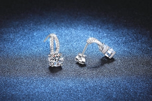 Close-up of elegant 1 carat moissanite stud earrings with sparkling halo and silver plating