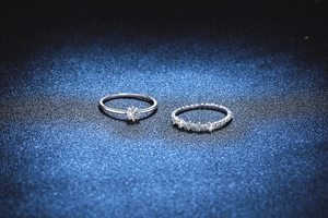 Macro di un set di anelli in argento S925 e moissanite con incastonatura a sei griffe su blu