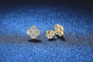 Detailed view of gold clover stud earrings with moissanite stones and beaded edges