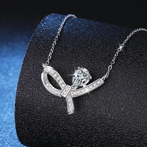 Collier nœud en argent S925 avec pendentif moissanite poire sur fond bleu foncé