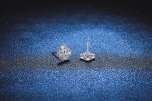Macro shot of silver S925 moissanite four-leaf clover stud earrings with beaded edge