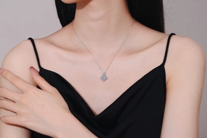 Close-up of s925 silver moissanite four-leaf clover pendant on a delicate chain