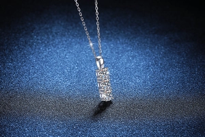 Detailed view of three-stone Moissanite pendant with linear four-prong setting in silver