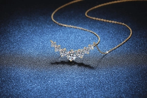 Macro shot of 1.7ct Moissanite smile pendant with gold chain on dark textured background