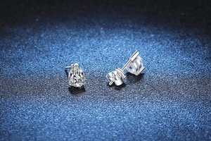 Macro shot of silver pear-cut moissanite stud earrings with secure butterfly backs
