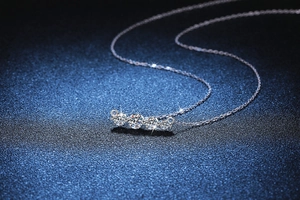 Vue macro d'un collier en argent 925 avec quatre pierres moissanite taille brillant en dégradé