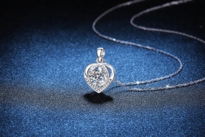 Macro shot of S925 sterling silver heart pendant with 1ct moissanite on blue background