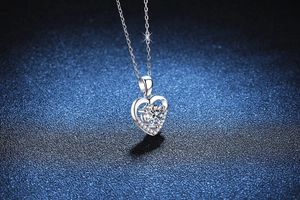 Détail macro du pendentif cœur en argent S925 avec moissanite 1ct sur socle bleu