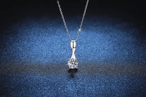 Macro view of rotating bow pendant with a 1-carat round brilliant moissanite stone