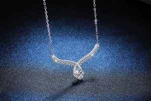 Macro shot of S925 sterling silver angel wing pendant with 1ct moissanite center stone