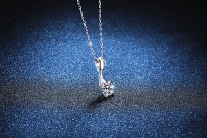Macro shot of S925 silver necklace featuring a 1 carat moissanite in a rotating bow pendant