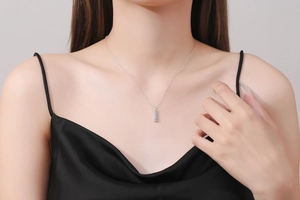 Detail of s925 silver necklace with three light blue round gemstones on collarbone