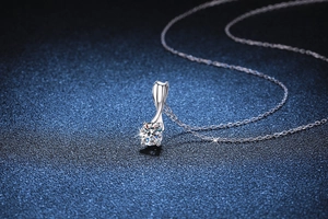Detailed close-up of a 1-carat moissanite pendant with a rotating silver bow design