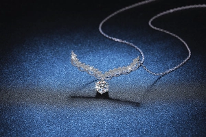 Gros plan d'un pendentif en moissanite de 1 carat avec ailes ondulées et chaîne en argent