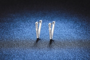 Macro shot of V-shaped 925 sterling silver earrings with shimmering pavé moissanite stones