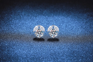 Detailed macro view of S925 sterling silver moissanite studs on starry blue background