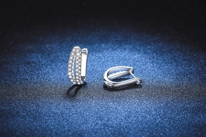 Vue macro de boucles d'oreilles créoles argentées avec double rangée de moissanite