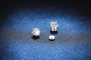 Macro shot of silver magnetic moissanite stud earring showing six-prong setting and sparkle