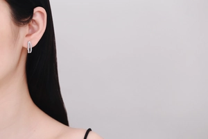 Détail de créoles en argent 925 avec moissanite pavée portées par un mannequin