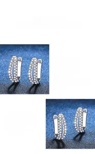 Détail macro de boucles d'oreilles C en argent S925 serties de pierres moissanites