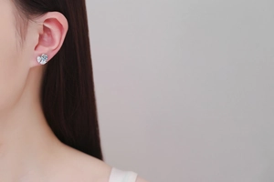Detail shot of a S925 sterling silver moissanite stud earring worn on the earlobe