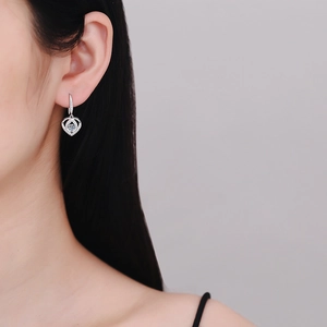 S925 sterling silver heart earrings with 0.6 carat moissanite stones on model