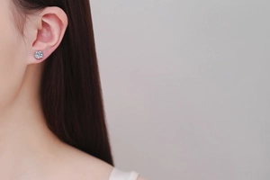 Gros plan d'une boucle d'oreille classique en moissanite à quatre griffes sur une oreille