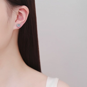 Classic six-prong Moissanite stud earrings in S925 sterling silver worn by a model