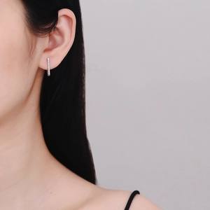 Sparkling S925 sterling silver V-shaped moissanite hoop earrings worn by a model