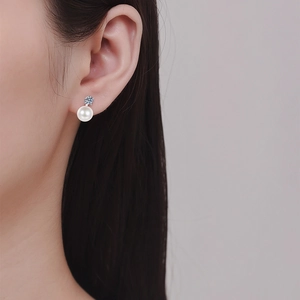 Elegant S925 sterling silver pearl earrings with sparkling moissanite on a model