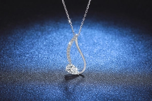 Macro detail of teardrop S925 silver pendant with Moissanite stones on blue background