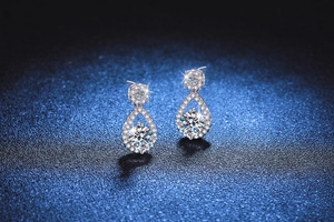 Macro detail of silver drop earrings featuring a 1 carat moissanite center stone