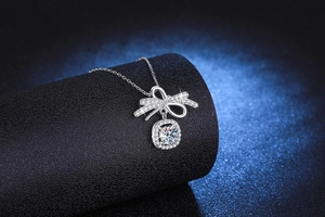 Détail du pendentif nœud en argent avec moissanite 1 carat et halo sur chaîne fine