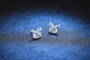 Macro shot of 925 sterling silver bow earrings with sparkling moissanite stones