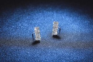 Macro shot of S925 sterling silver three-stone moissanite earrings with prong setting