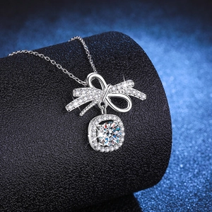 Collier nœud en argent S925 avec pendentif moissanite 1ct et sertissage halo sur fond sombre