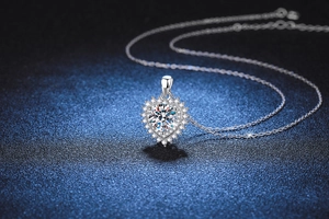 Close-up of heart-shaped 925 sterling silver pendant with 2ct moissanite on blue background