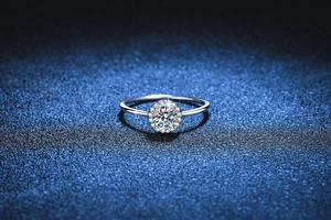 Macro detail of a round brilliant cut moissanite ring with a sparkling pavé halo setting