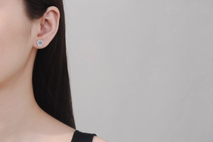 Close-up of S925 sterling silver camellia stud earring with 1ct moissanite on ear