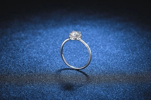 Close-up of a halo-set s925 silver moissanite ring against a starry blue background